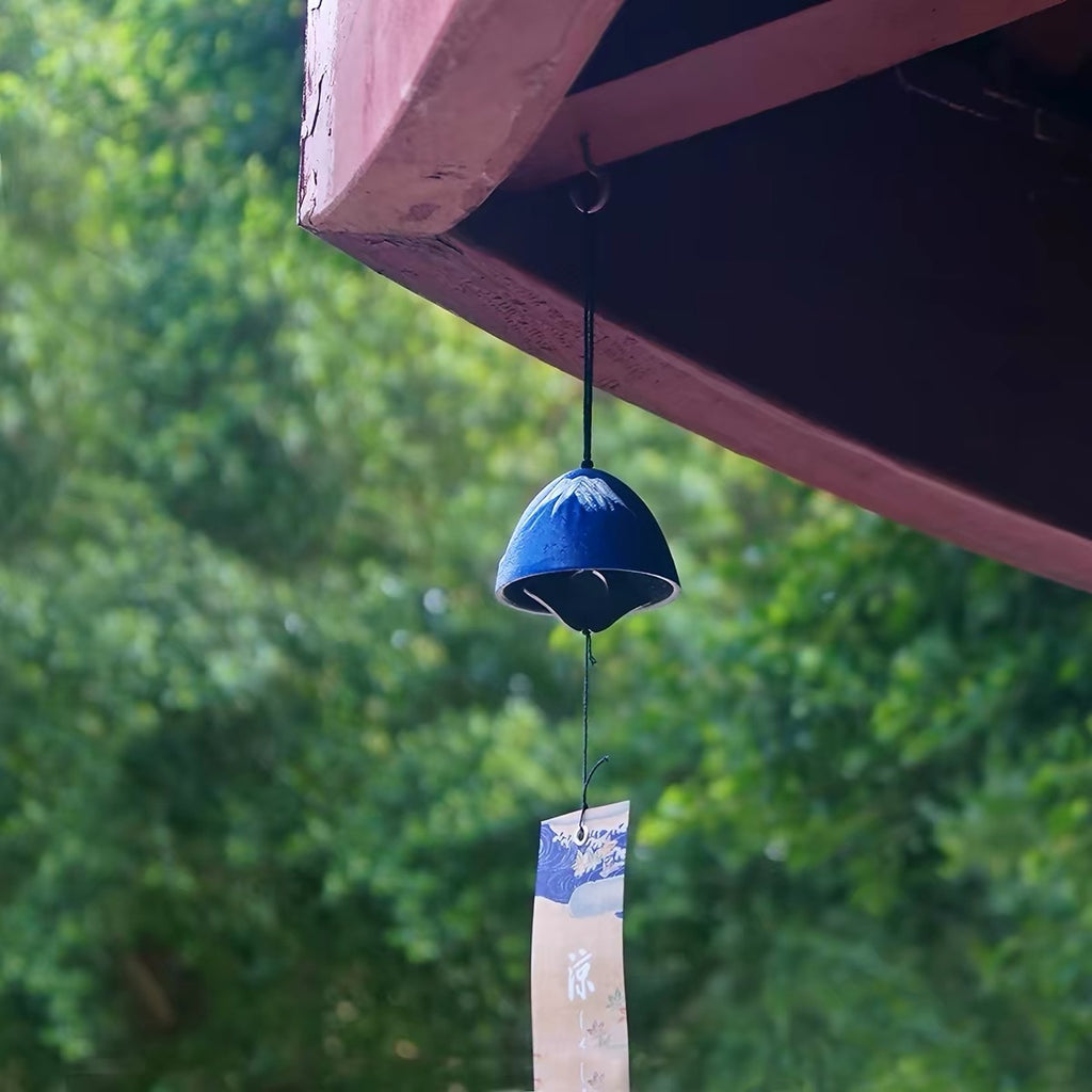 Handcrafted Japanese Mount Fuji cast iron furin wind chime hanging beneath a roof eave.