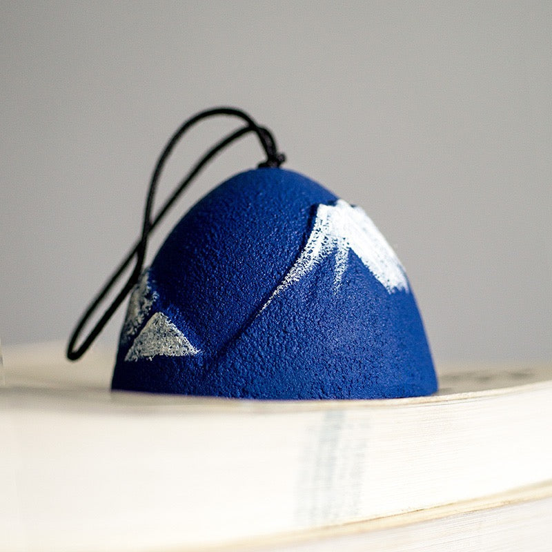 Close-up of a handcrafted Japanese Mount Fuji cast iron furin wind chime with a blue finish.