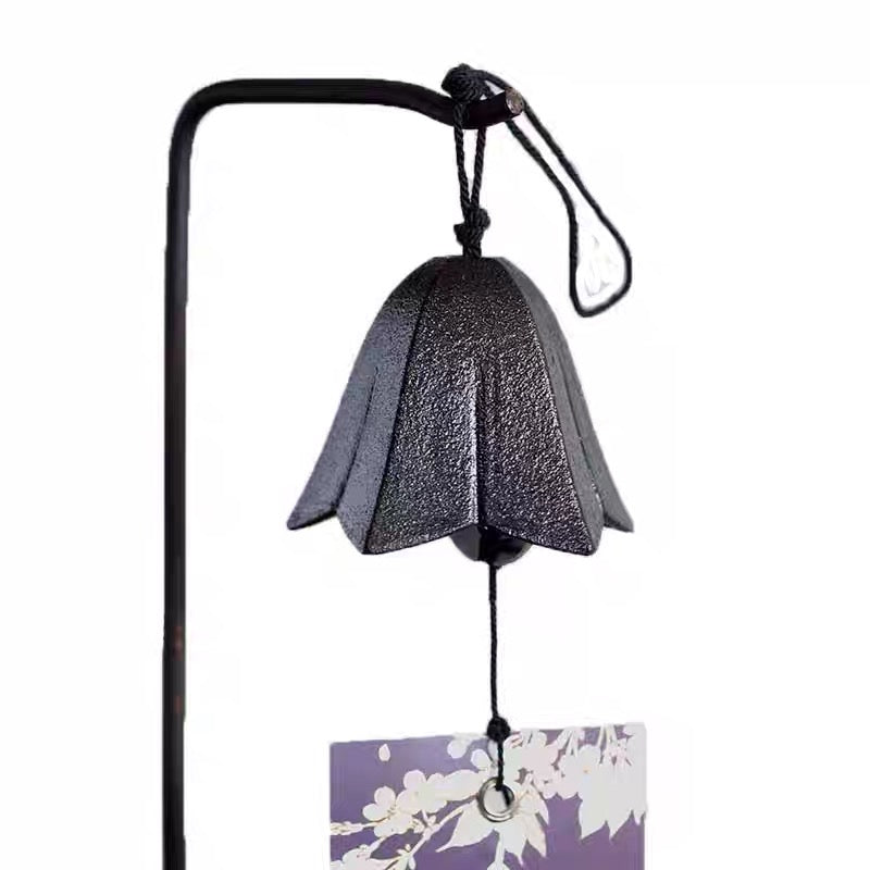 Close-up of a handcrafted Japanese cast iron gentian flower wind chime hanging on a decorative display stand.