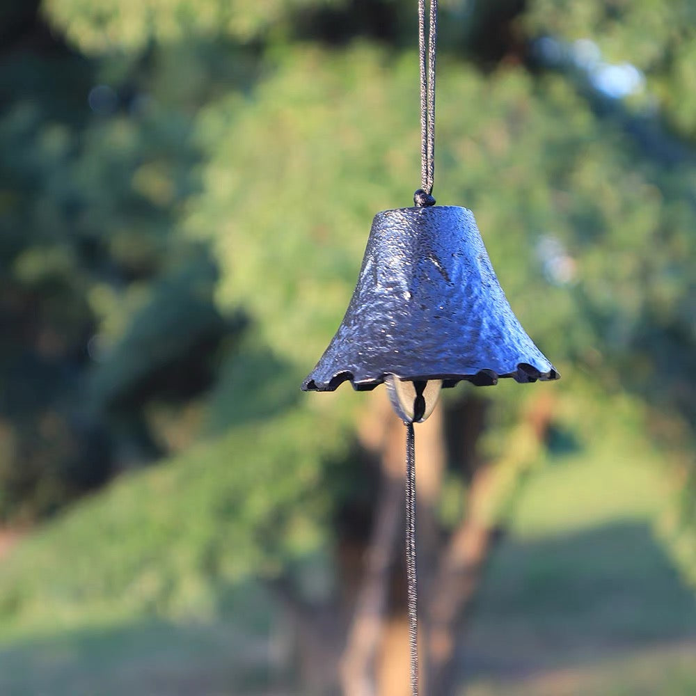 Close-up of a handcrafted Japanese cast iron furin wind chime with an organic leaf-inspired design.