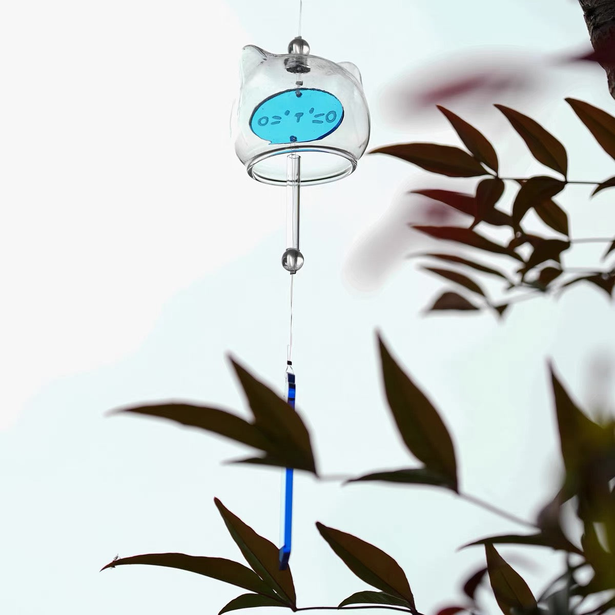 Close-up of a handcrafted Japanese glass cat furin wind chime featuring an adorable blue kitten design.