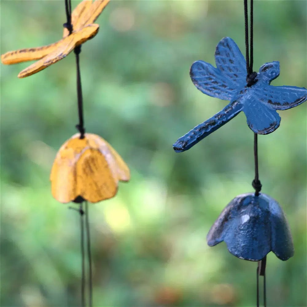 Close-up of blue and yellow dragonfly cast iron wind chimes with textured details