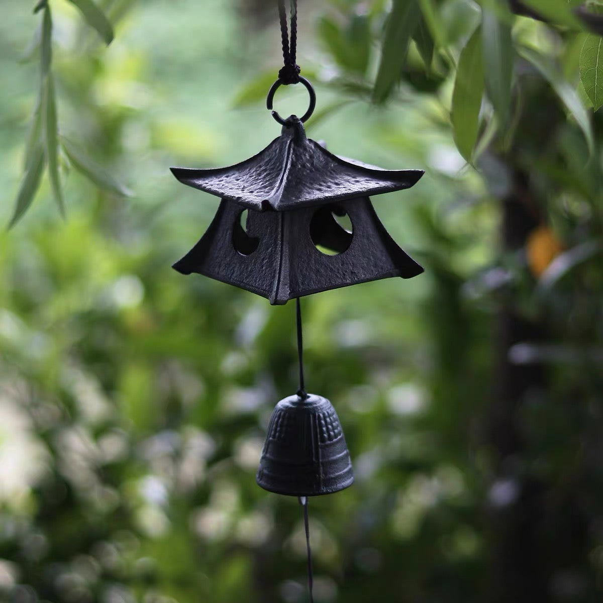 Close-up of a Japanese black cast iron pagoda furin wind chime with textured finish