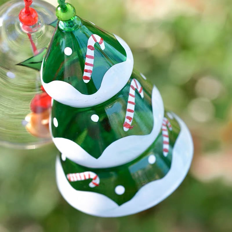 Close-up of a green Christmas tree glass wind chime with candy cane and snow details