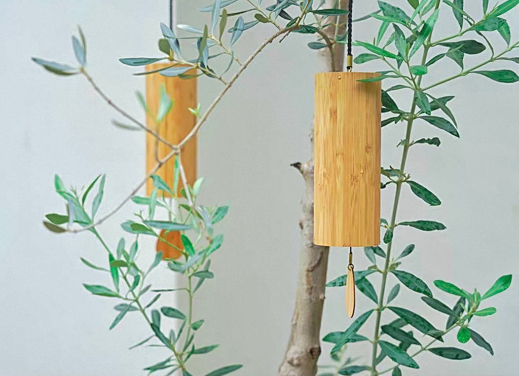 Japanese bamboo wind chime displayed indoors beside green branches for a calm meditation and home decor look.