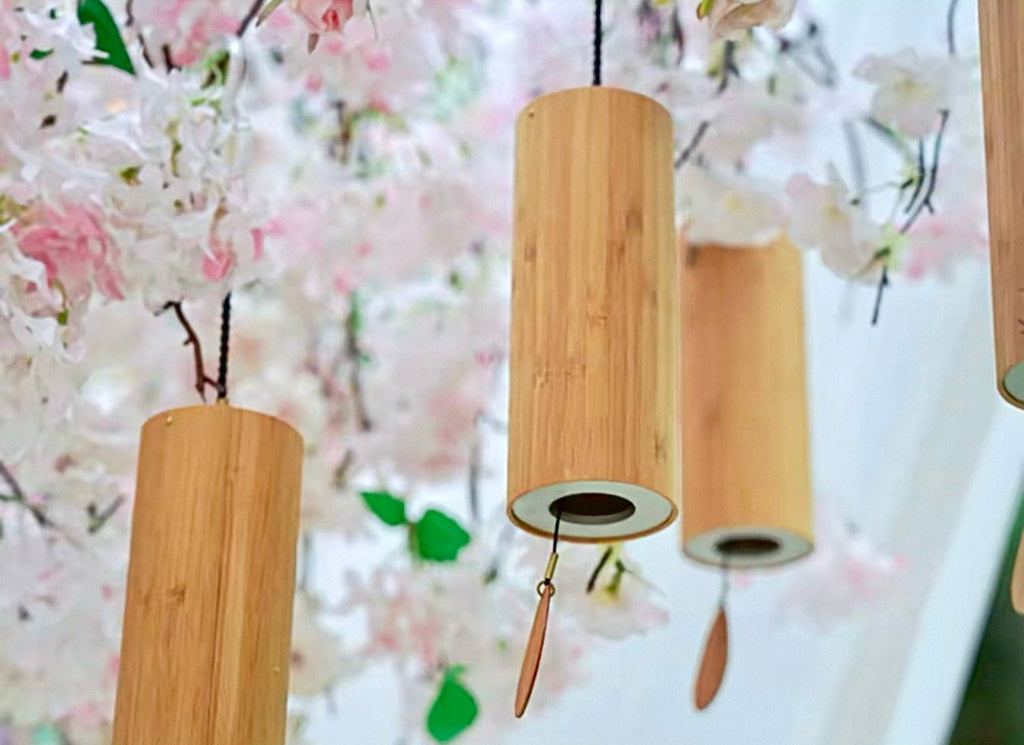 Japanese bamboo meditation wind chimes hanging beneath soft cherry blossoms for peaceful Zen-inspired decor.