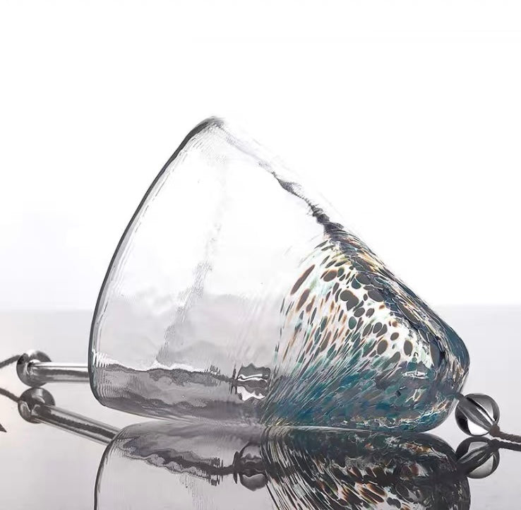 Blue Japanese handmade thick glass wind chime lying on a reflective surface, showing its textured glass finish.