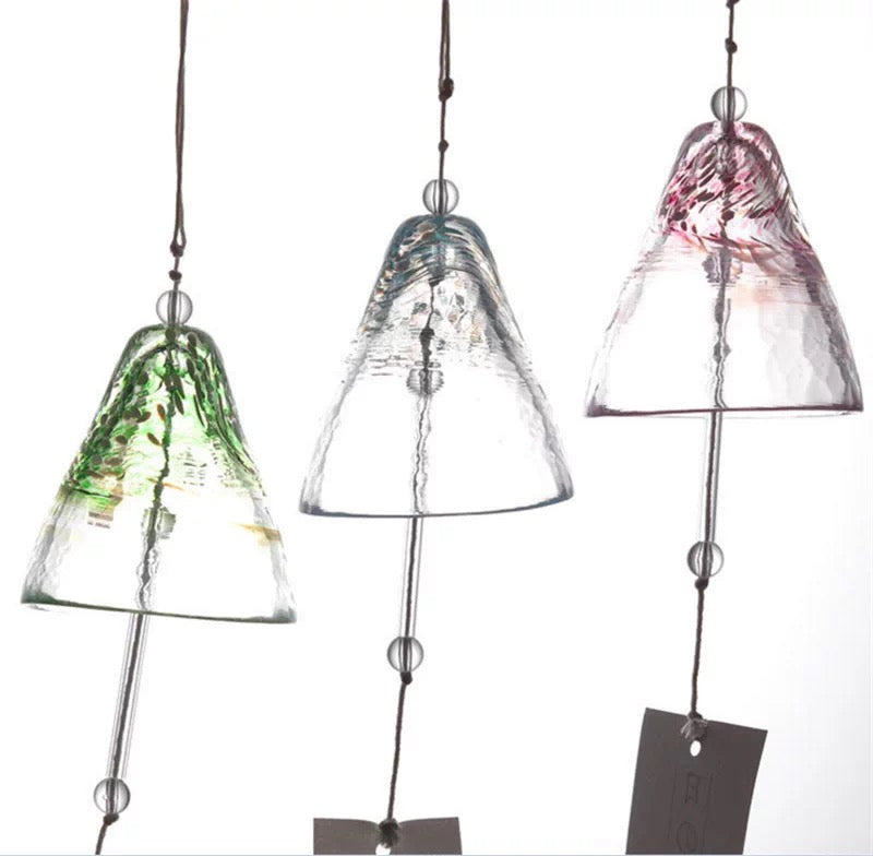 Close-up of Japanese handmade thick glass wind chimes in green, blue, and pink hanging with rustic cords.