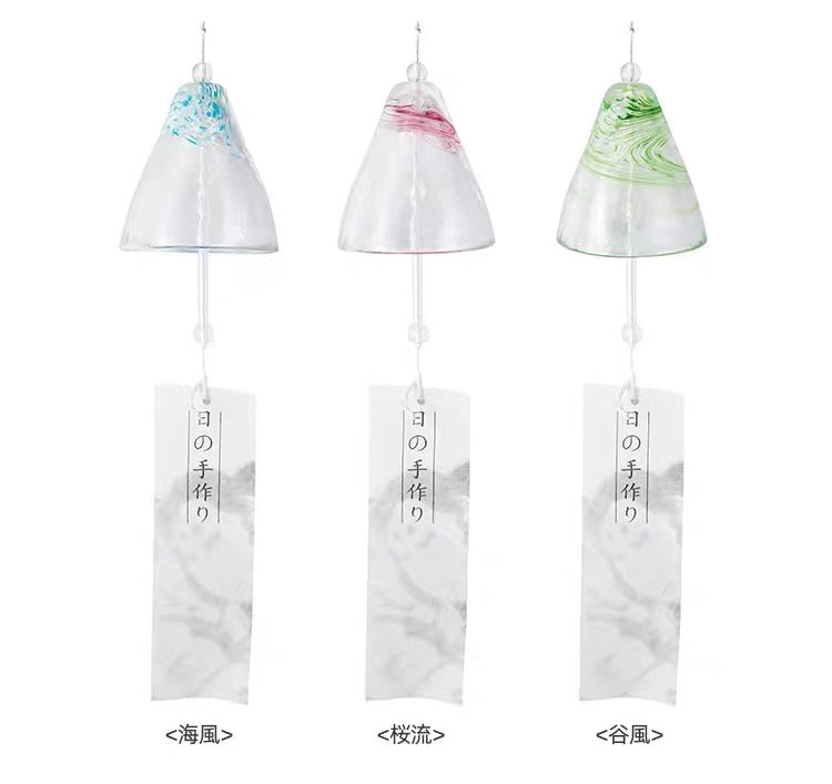 Japanese handmade thick glass furin wind chimes in blue, pink, and green with paper tanzaku strips on a white background.