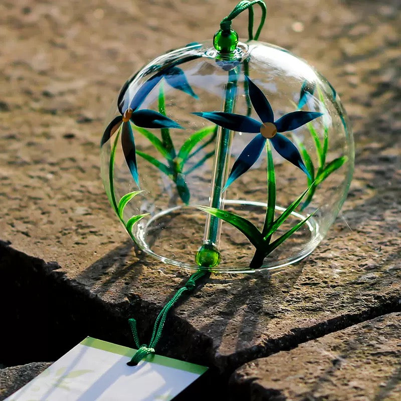  Japanese glass furin wind chime with blue floral design displayed on a stone surface