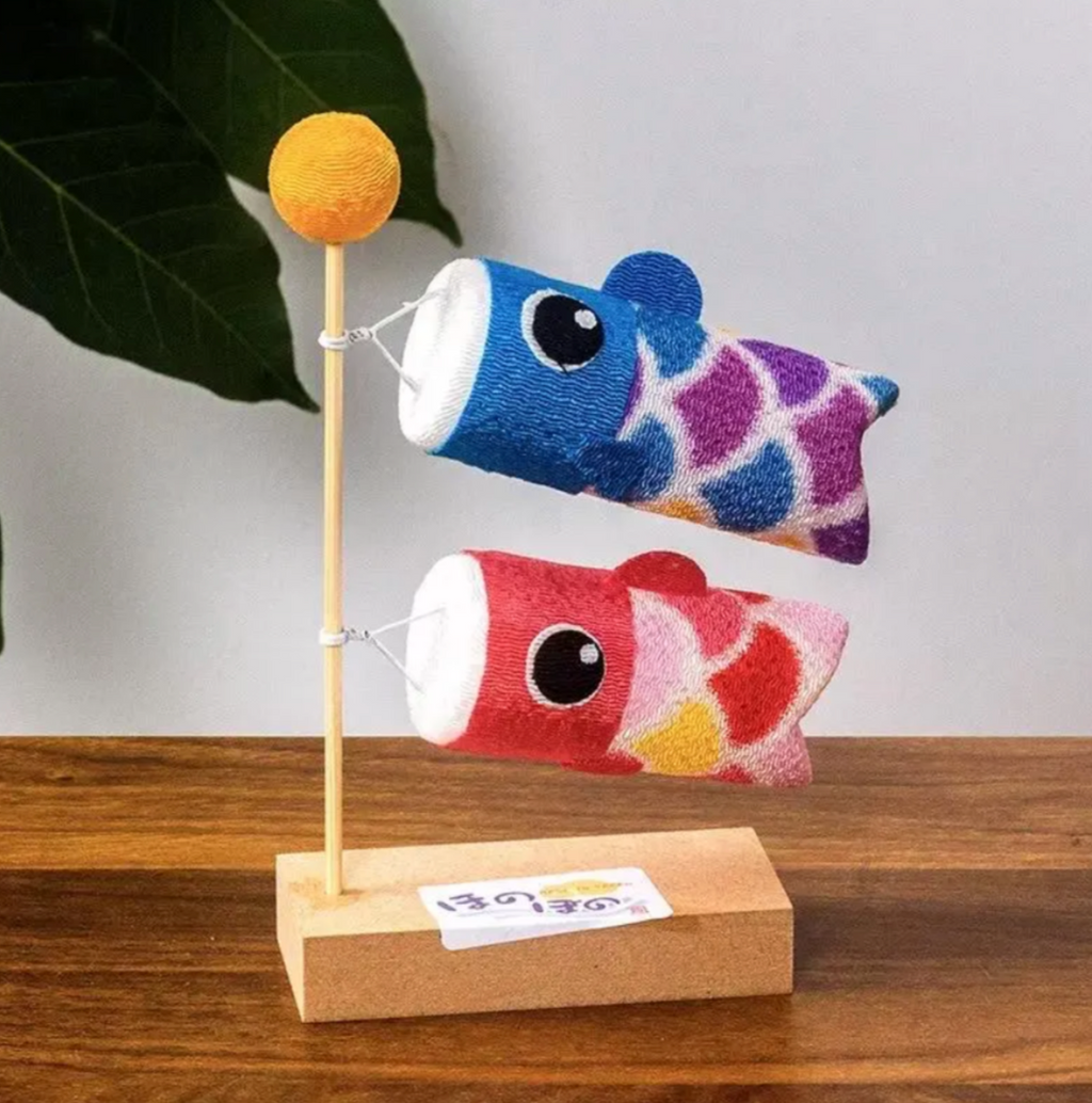 Handcrafted Japanese blue and red koinobori desk ornament displayed on a wooden stand.